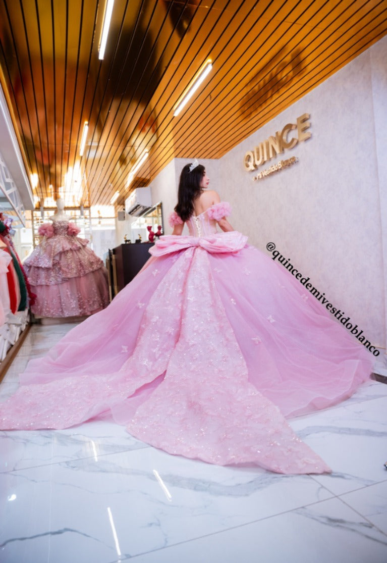 Vestido de quinceañera rosa con corset, moño gigante y mariposas