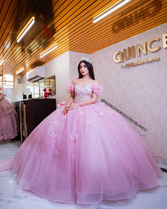 Vestido de quinceañera rosa con corset, moño gigante y mariposas