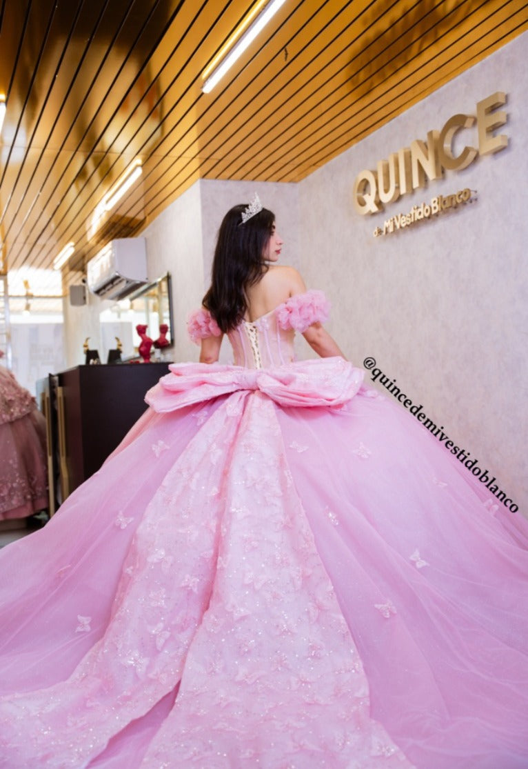 Vestido de quinceañera rosa con corset, moño gigante y mariposas