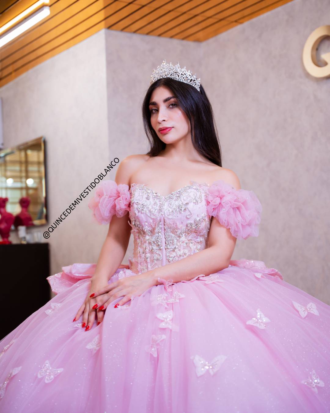 Vestido de quinceañera rosa con corset, moño gigante y mariposas